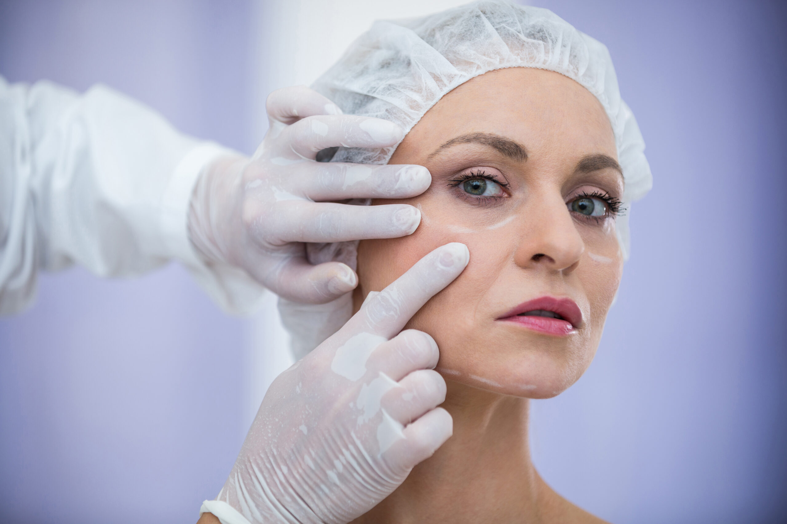 doctor-examining-female-patients-face-cosmetic-treatment-scaled.jpg